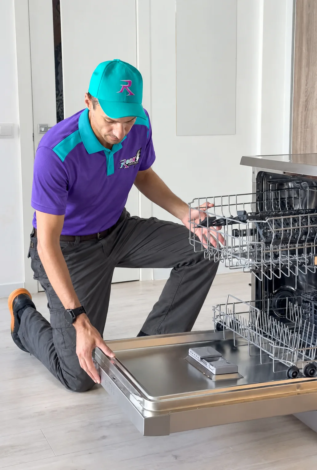 Rock technician servicing a dishwasher in a home kitchen